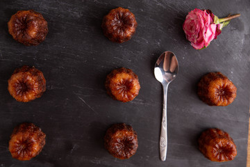 French pastry Caneles de bordeaux rum and vanilla flavor thick caramelized crust on black slate plate..