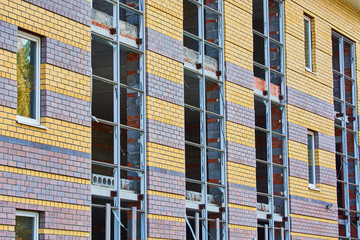 Brick building under construction with windows.