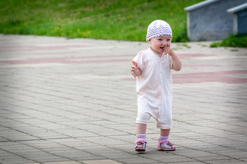 A small child in a white suit running around the paved path from the quay of the river port