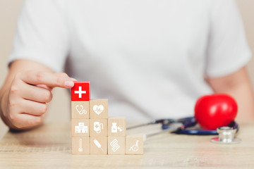 Health Insurance Concept,hand arranging wood block stacking with icon healthcare medical.
