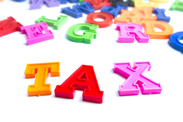 Fototapeta premium Heap of plastic colored alphabet letters close up. Tax