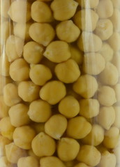 a glass jar with cooked chickpeas on a white background