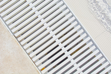 Stock white grate for diversion of water in pool.