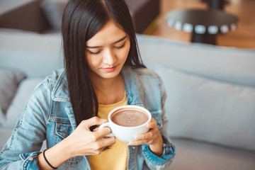 Attractive Asian woman drinking coffee.cheerful girl drinking coffee or tea in morning