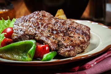 Portions of grilled beef steak with grilled potatoes and paprika