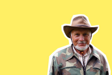 Fototapeta premium Middle aged traveler. Portrait of a handsome adult man with a gray beard and hat in camouflage clothing.