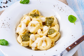 Tortellini di formaggio with basil pesto and cheese sauce