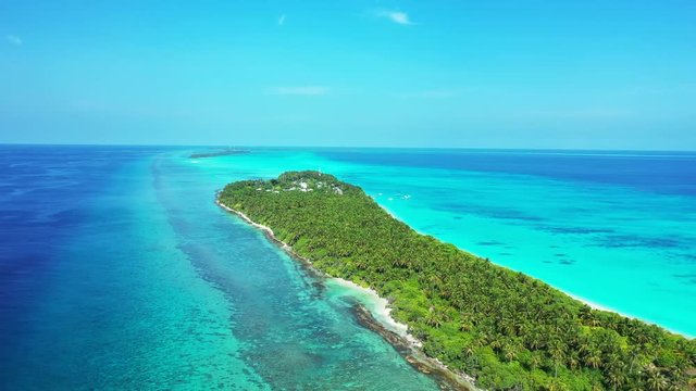 Aerial view of a tropical island with palm trees on it. In a strip of truquoise water in the sea of Thailand. Dolly out