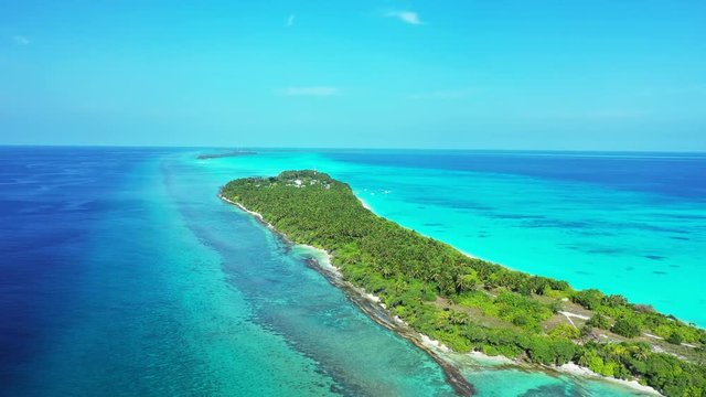 Aerial view of a tropical island with palm trees on it. In a strip of truquoise water in the sea of bali.