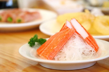 Crab stick japan food on white radish on wood table, look delicious.