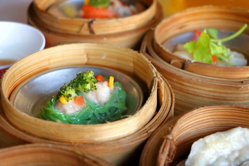 Close up green egg noodle served with steamed pork and shrimp in bamboo basket in Chinese dim sum...
