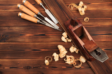 chisels plane and sawdust on a wooden table.