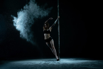 Female dancer posing with pylon in dust