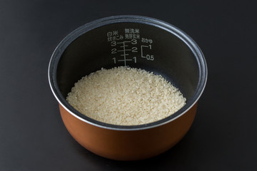黒背景に釜にお米が入っている