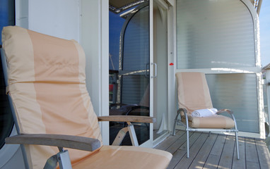 Bequeme Sonnenstühle auf Balkon von Kabine auf Luxus-Kreuzfahrtschiff