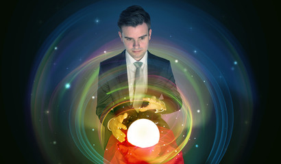 Young handsome man looking to the future of the universe in a crystal ball
