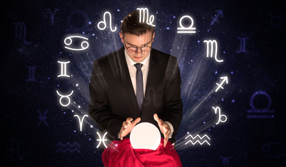Young handsome astronaut looking for inspiration in his crystal magic ball

