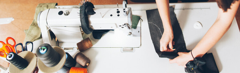 Tailor workshop. Top view cropped shot of seamstress drafting fabric pattern in studio.