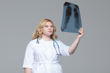 Young female doctor looking at the x-ray picture of lungs.