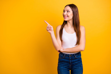 Close up photo beautiful she her lady perfect appearance hand arm index finger indicate empty space news advising buy buyer wear casual jeans denim white tank-top isolated bright yellow background