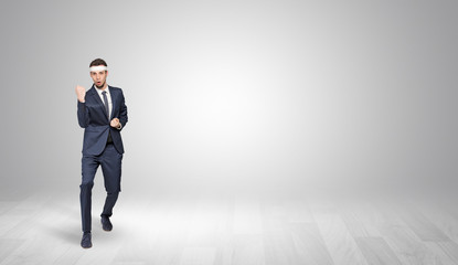 Fototapeta premium Young businessman in suit fighting in an empty space 