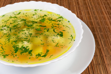 Fragment of chicken meatballs soup in the white dish
