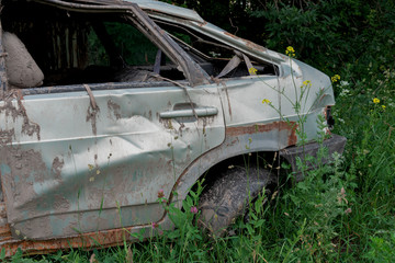 the body of a crashed car drowned in mud stands on the grass