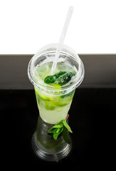 Mojito in plastic cup, mint on a dark reflective surface