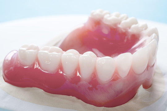Close up , Complete denture or full denture on blue background.