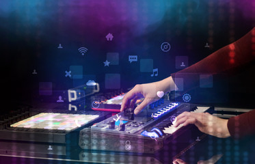 Hand mixing music on dj controller with social media concept icons
