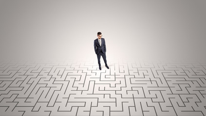 Elegant businessman looking for a solution in a middle of a maze

