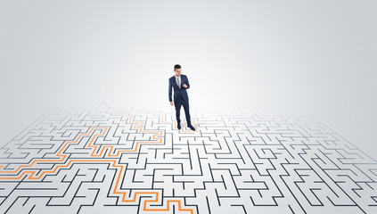 Young entrepreneur standing in a middle of a labyrinth with the solution
