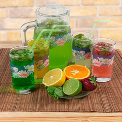 Cold mint drinks with fruit and berry on table mat