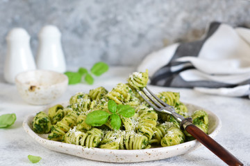 Vegan pasta with spinach, basil and parmesan. Lunch on the kitchen table.