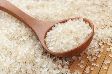 Pure brown rock sugar and spoon on sugar background