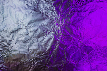 Purple white metallic background made of neon lights foil. Trendy duotone texture