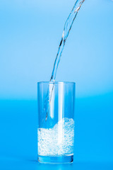 Close up pouring purified fresh drink water from the bottle on table