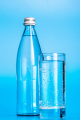 Glass water bottles on a light blue background