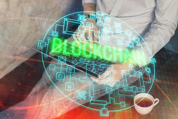 Crypto currency theme hologram with businessman working on computer on background. Concept of...
