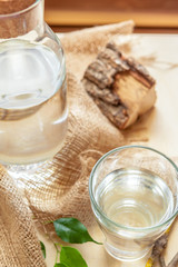 Bottle with clean water and the green leafs background close up