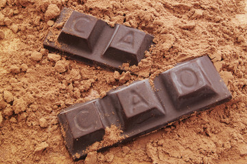 Chocolate bars with word CACAO on cacao powder background
