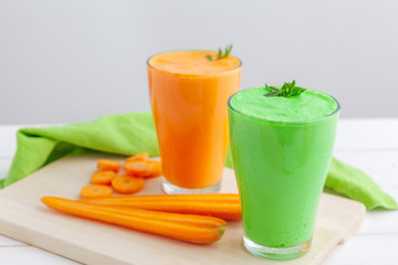 Green smoothie in glass over rustic wooden background