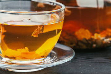 Cup of tea and tea leaves on wooden table