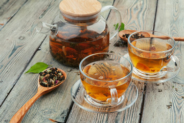 Cup of tea and tea leaves on wooden table