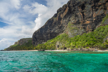 Beautiful Tropical beach in sunny day. Uninhabited island. Landscape of a tropical island and rocky mountains