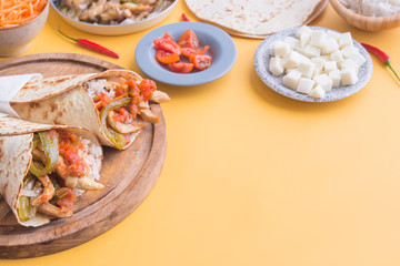fajitas y sus ingredientes en fondo amarillo