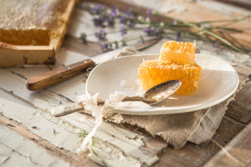 Honey comb  from honey dipper in wooden bowl. Close-up. Healthy organic Thick honey dipping from...