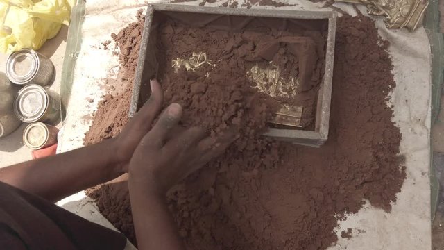 Indian metal workers casting Hindu God and Goddess idols using recycled up-cycled melted metal from everyday objects at a makeshift roadside workshop in India- 4k slow-motion handheld stabilized 