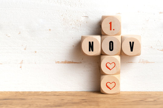 1st November date on wooden blocks formed as a cross on a table with copy space on a wall All Saints Day in Catholicism