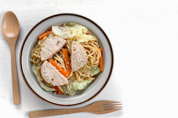 top view of stir fried japanese noodles with vietnamese pork sausage in a ceramic dish. asian homemade style food concept.
